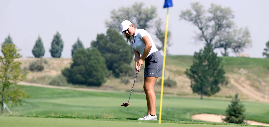 A UCCS golfer sinks a putt.